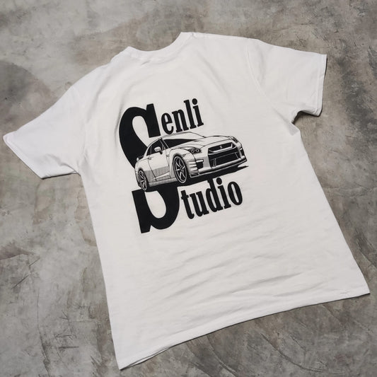 Parte trasera de la camiseta GTR Tee sobre el suelo, con ilustración de Nissan GTR