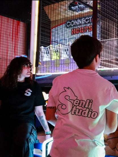 Modelo tirando a canasta con camiseta blanca de espaldas y modelo femenina con camiseta negra Basic T-Shirt de frente