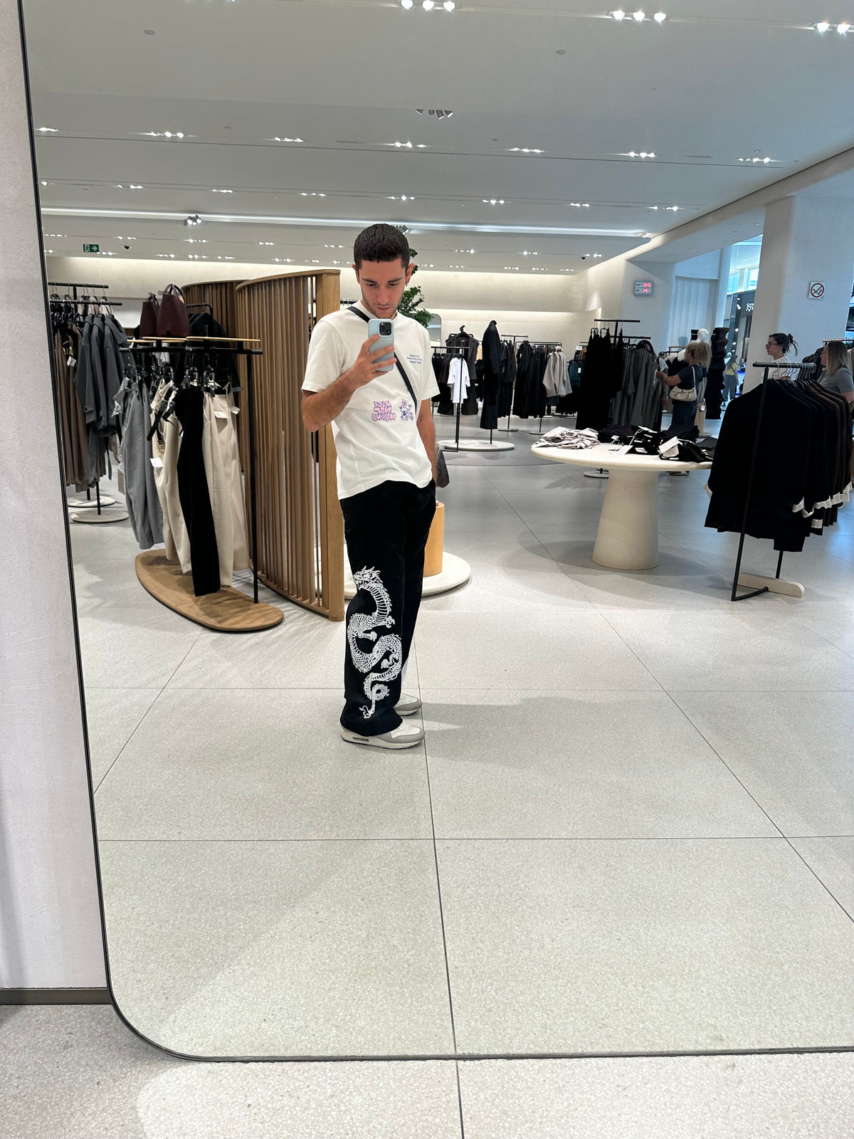 Modelo con el pantalón TDB Pants, pierna derecha con estampado de dragón