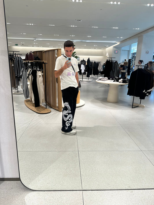 Modelo con el pantalón TDB Pants, pierna derecha con estampado de dragón