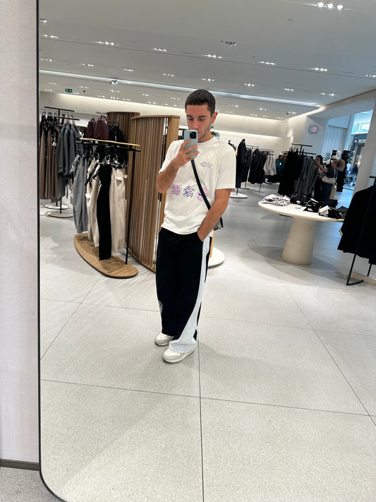 Modelo con el pantalón TDB Pants, pierna izquierda con línea blanca